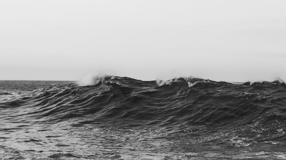 a black and white photo of a wave in the ocean