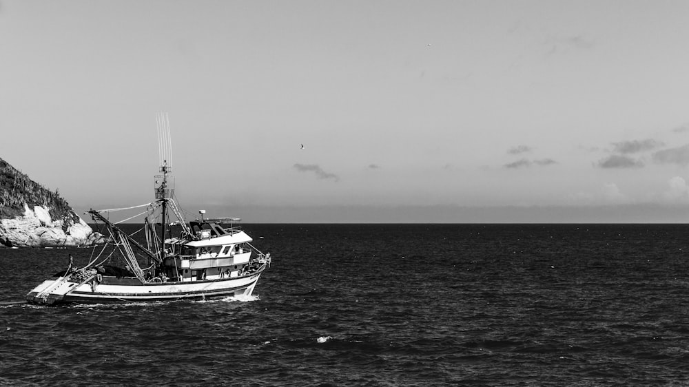 a black and white photo of a boat in the ocean