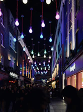 A vibrant street scene capturing everyday people engaged in lively conversation under colorful city lights.