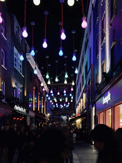 A lively street scene with local business owners chatting under warm streetlights at night