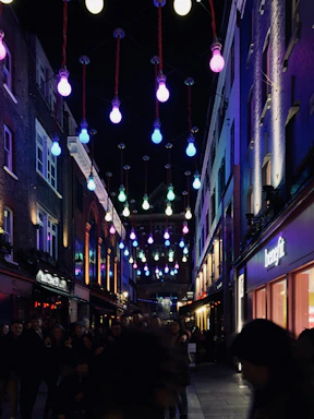 A lively street scene in Cali with people dancing salsa under colorful lights.