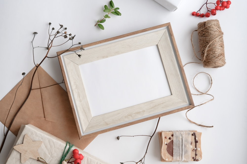 un cadre photo blanc assis sur une table à côté de ficelle de jumeau