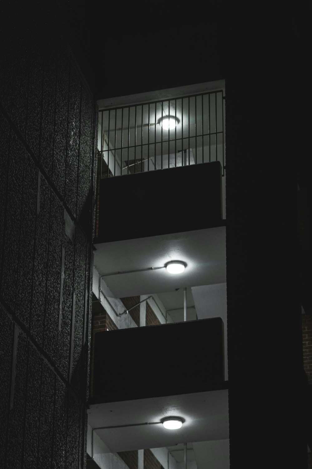 Un edificio alto con balcones iluminados por la noche