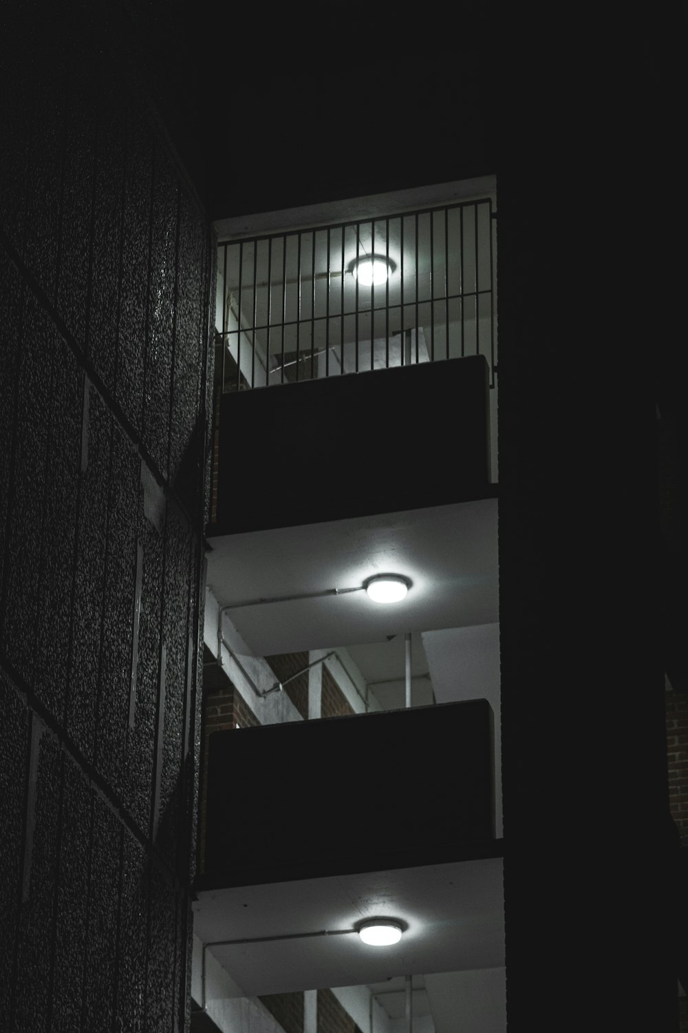 Un edificio alto con balconi illuminati di notte