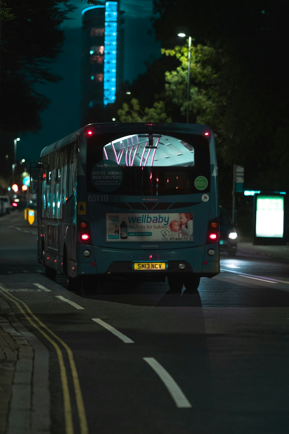 a bus driving down a city street at night