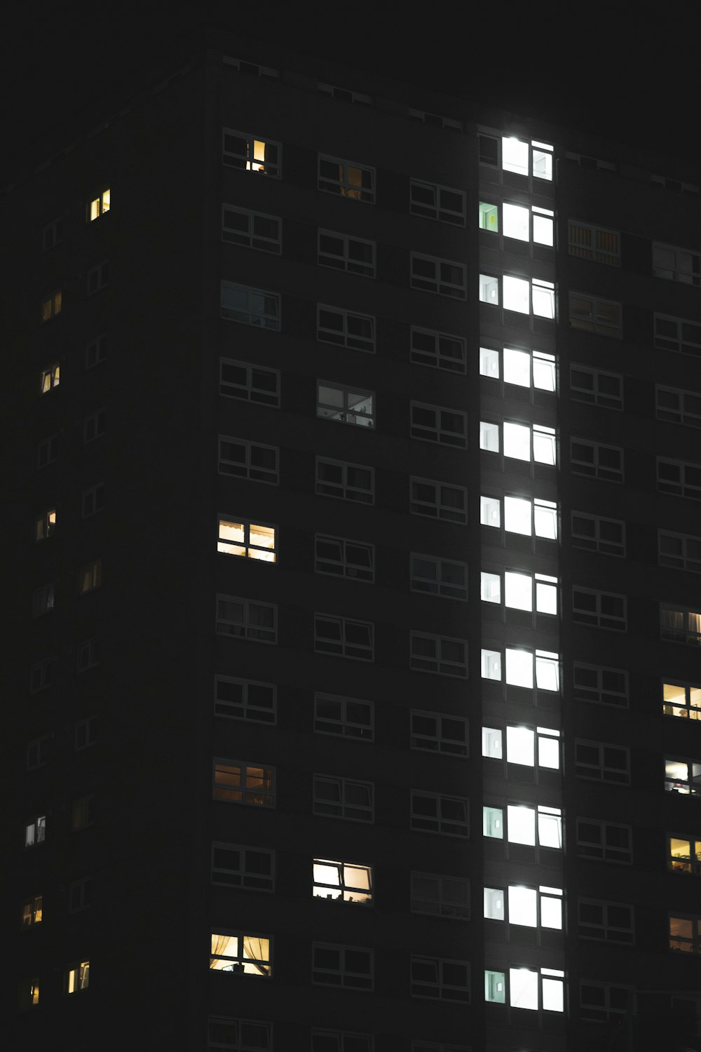 a tall building with many windows lit up at night