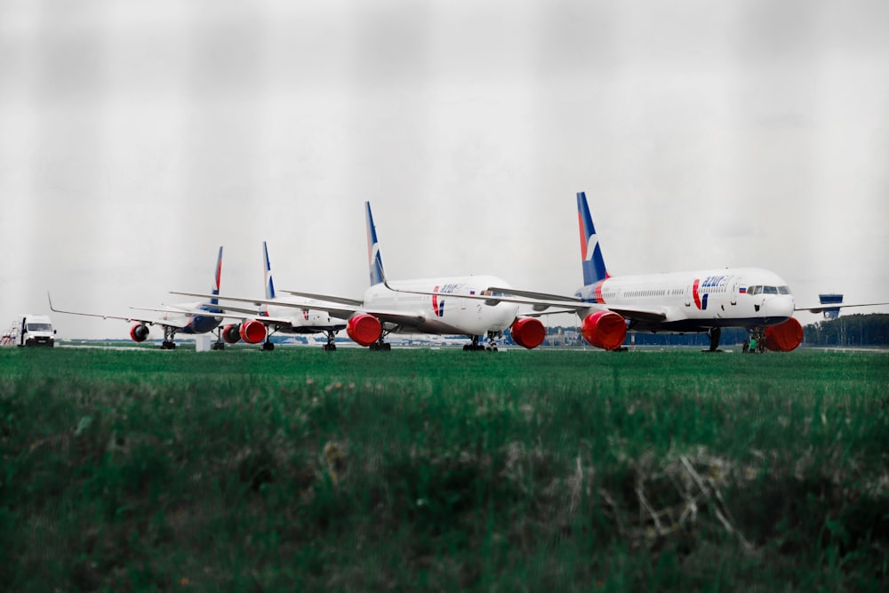 a row of airplanes sitting on top of an airport runway