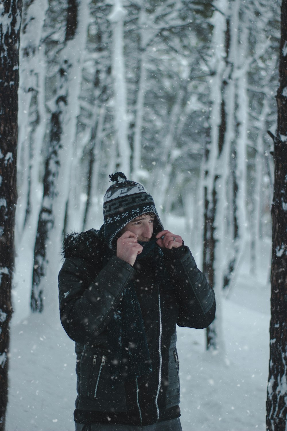 a person standing in the snow in front of trees