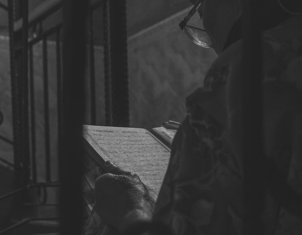 a black and white photo of a person reading a book