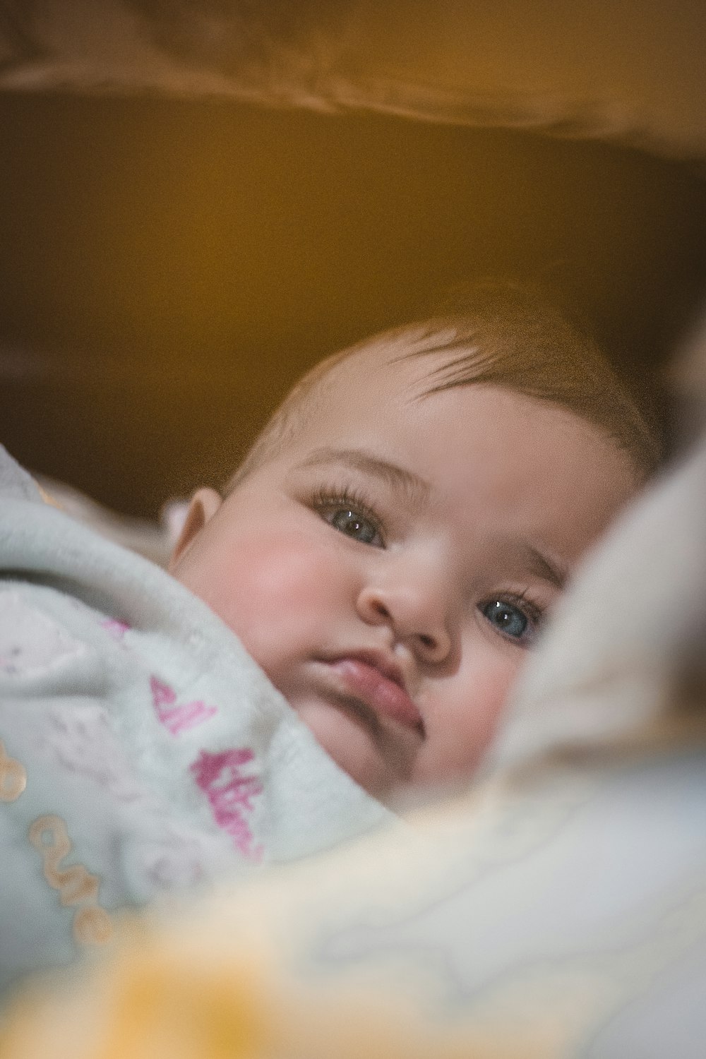 a small child laying in a bed with a blanket