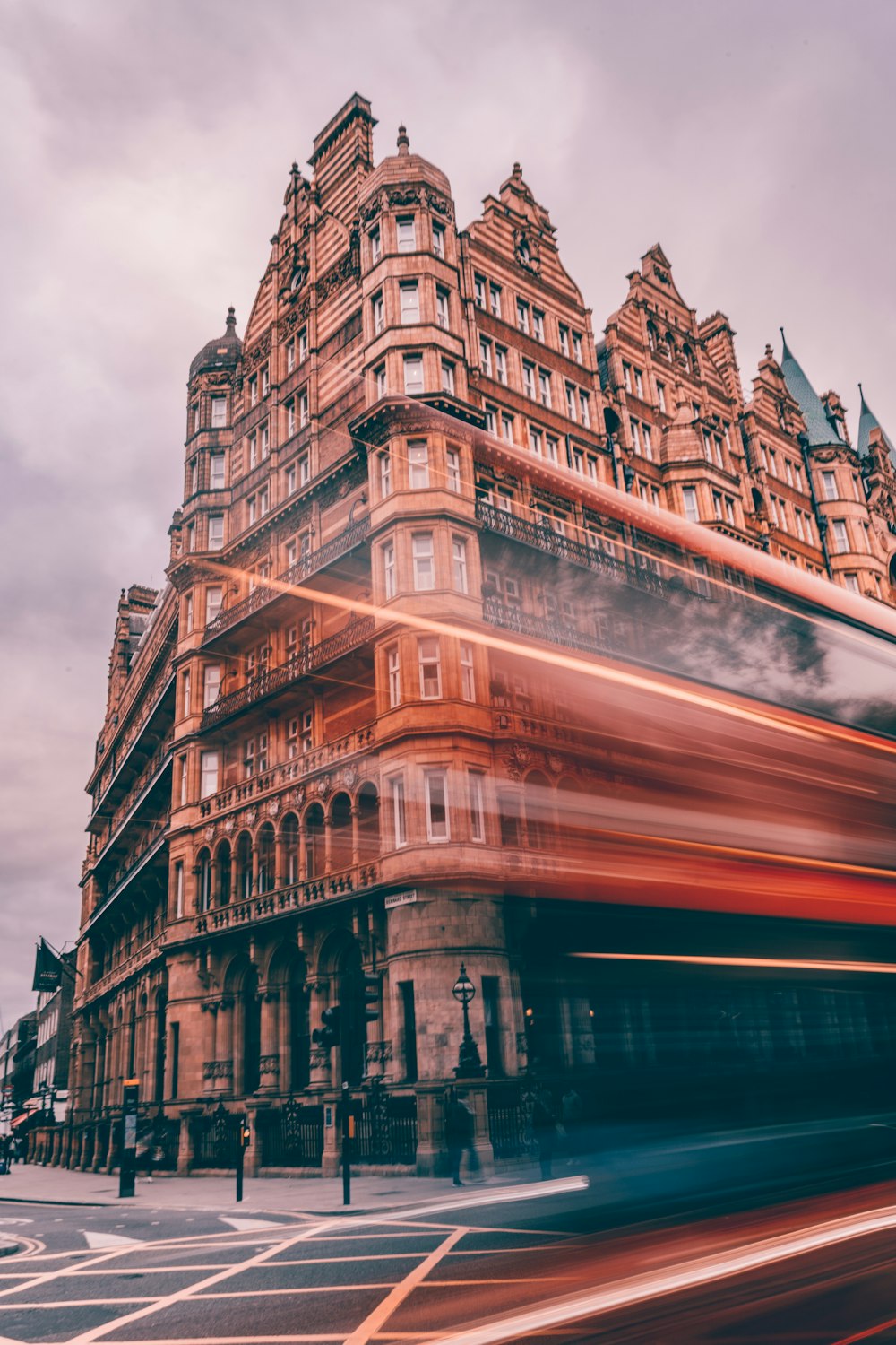 a double decker bus driving past a tall building