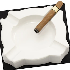 Minimalist black ashtray with a golden rim holding a burning cigar