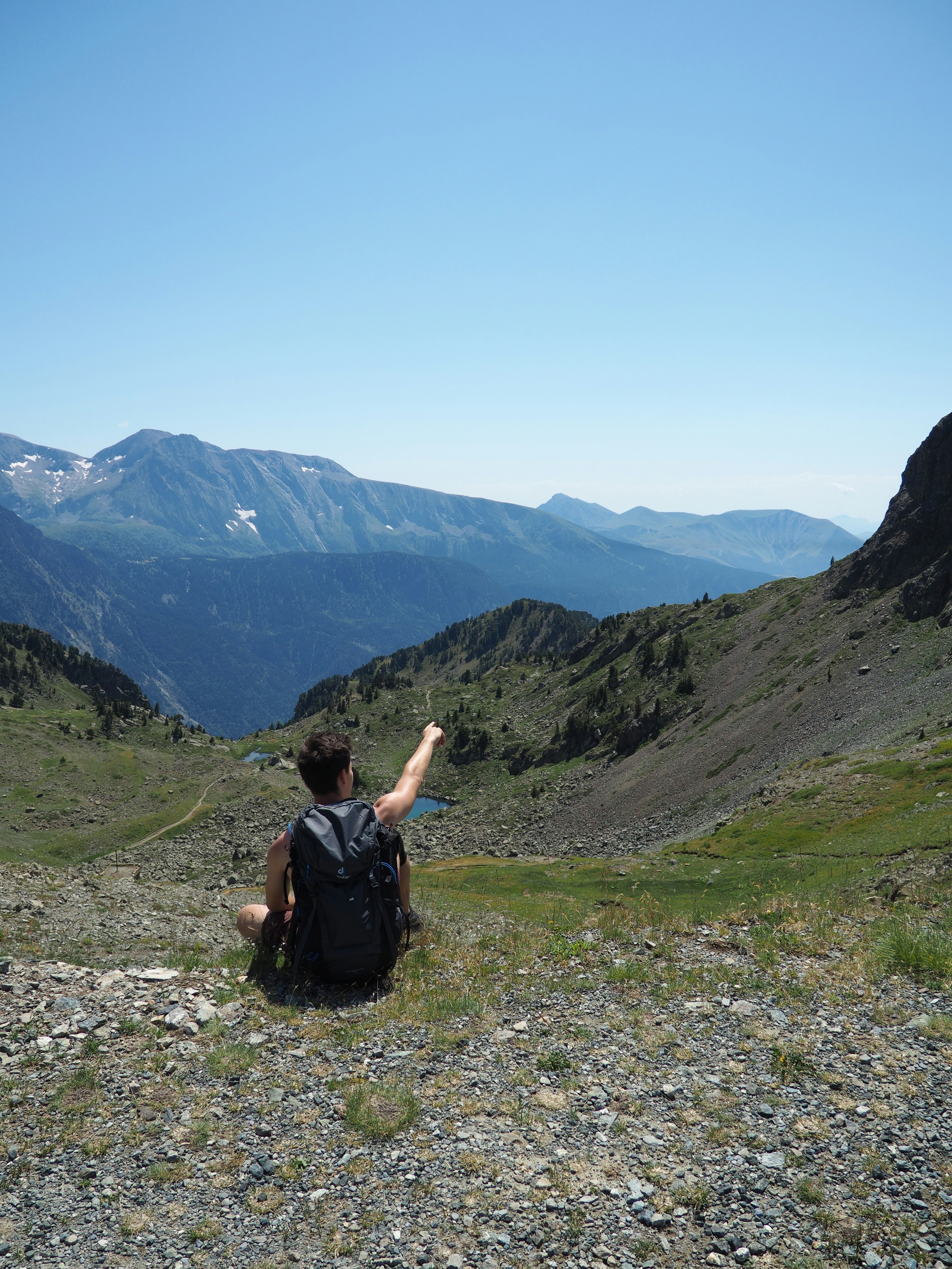 Un hombre con una mochila sentado en la cima de una montaña