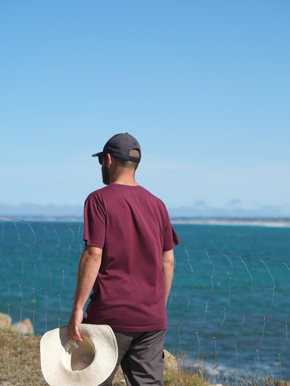 a man with a hat is looking at the water