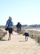a group of people walking down a dirt road