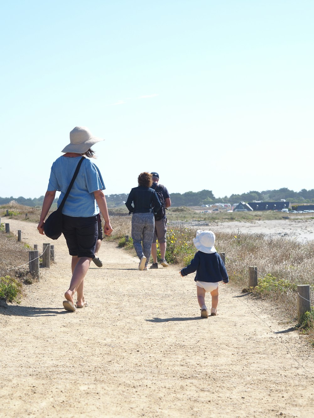 a group of people walking down a dirt road