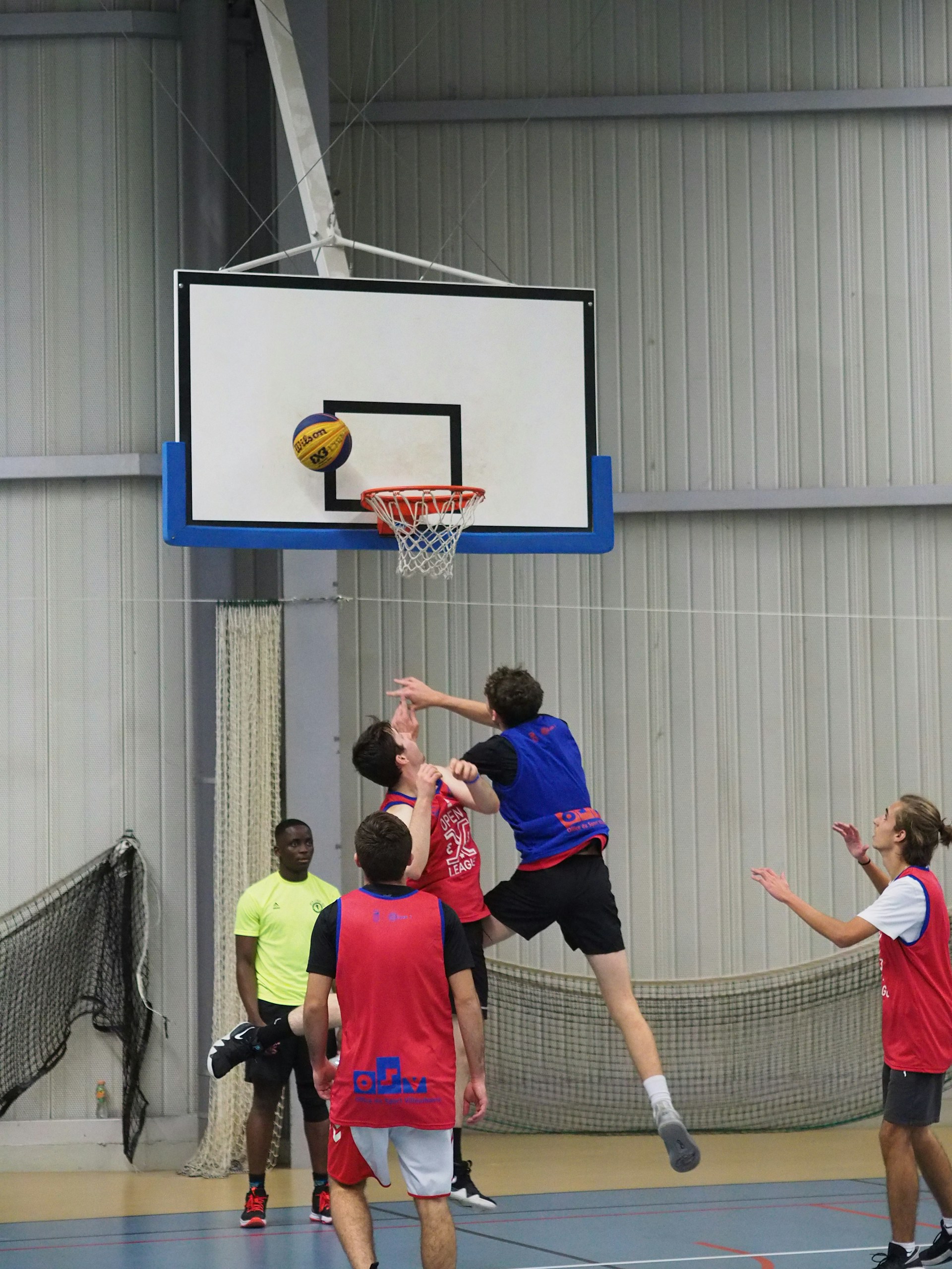 a group of young men playing a game of basketball