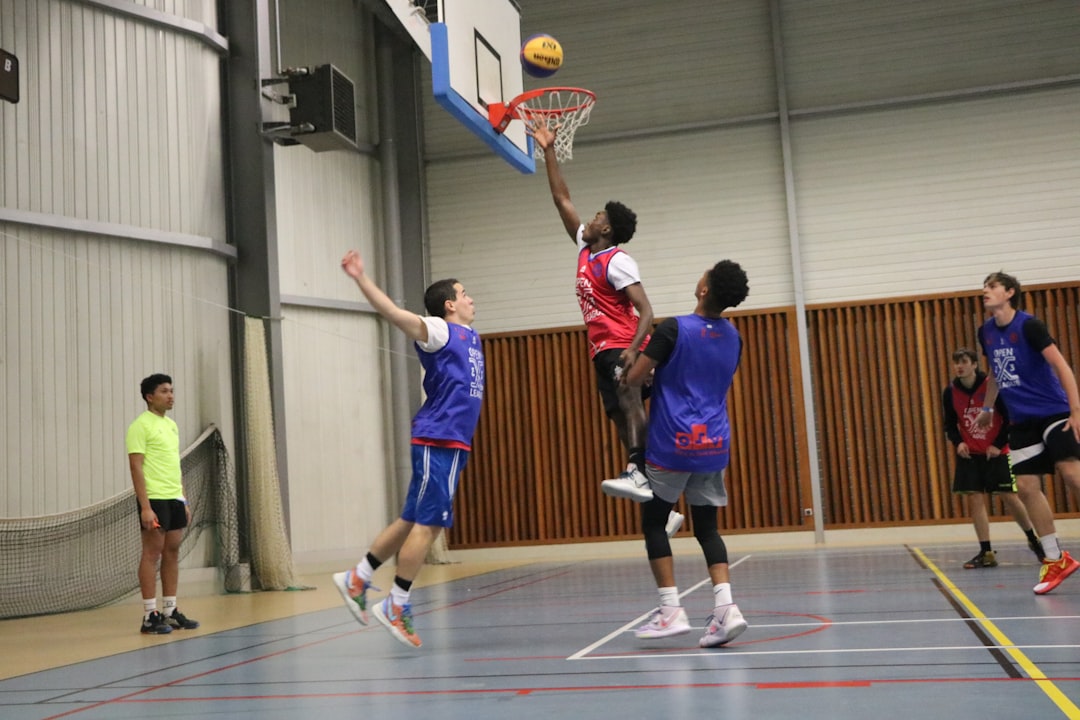 a group of young men playing a game of basketball,