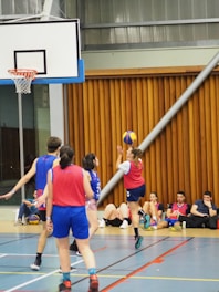 a group of young people playing a game of basketball
