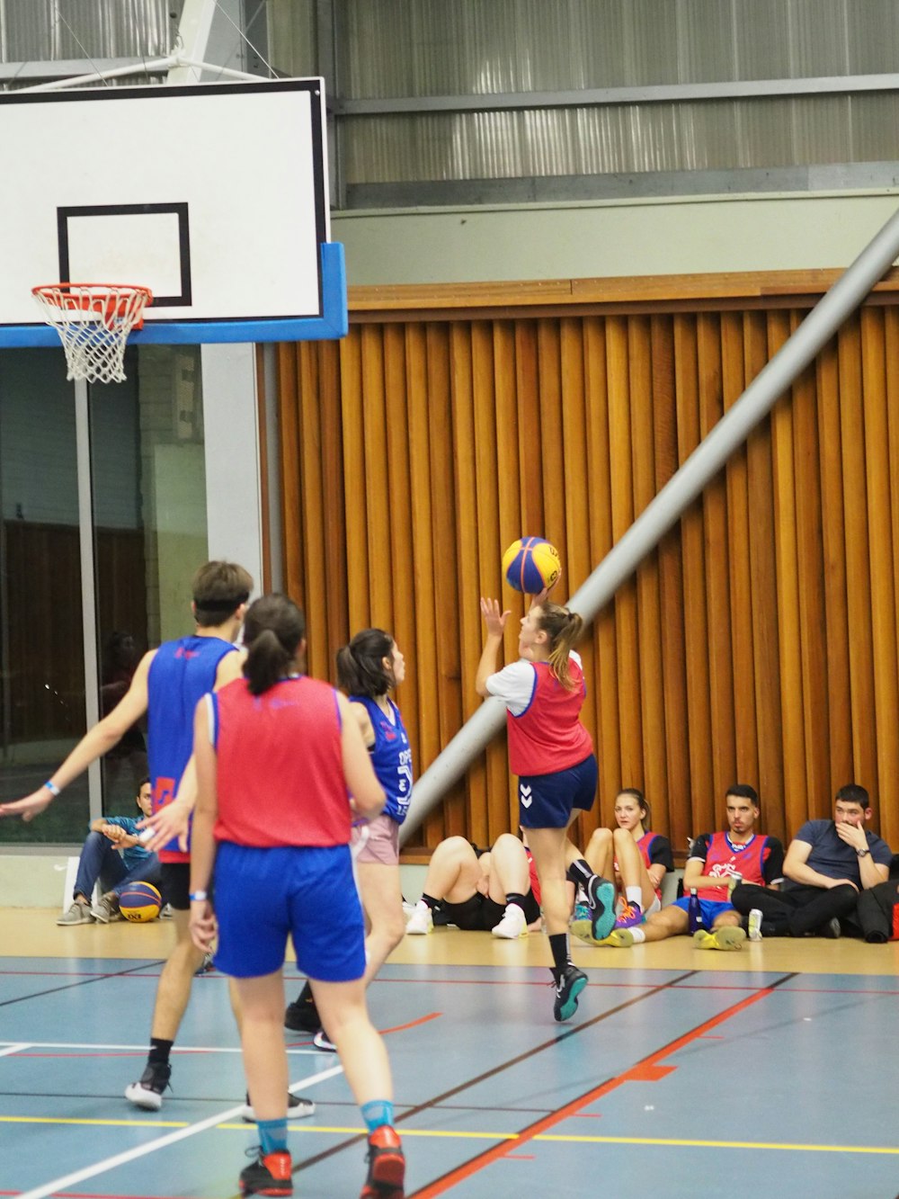 a group of young people playing a game of basketball