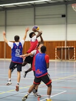 a group of young men playing a game of basketball