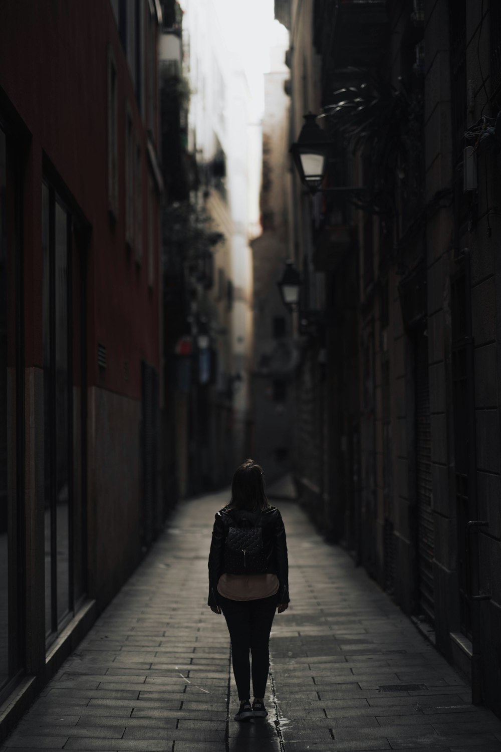 a person walking down a narrow alley way