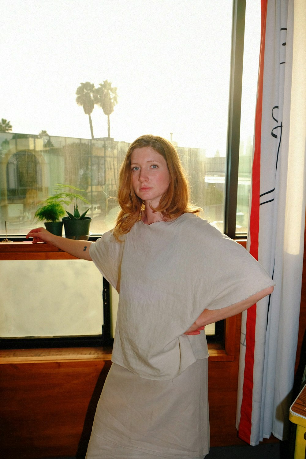 a woman standing in front of a window