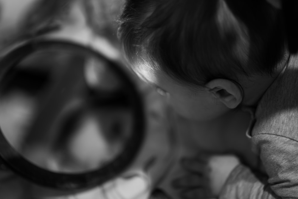 a woman is looking through a magnifying glass