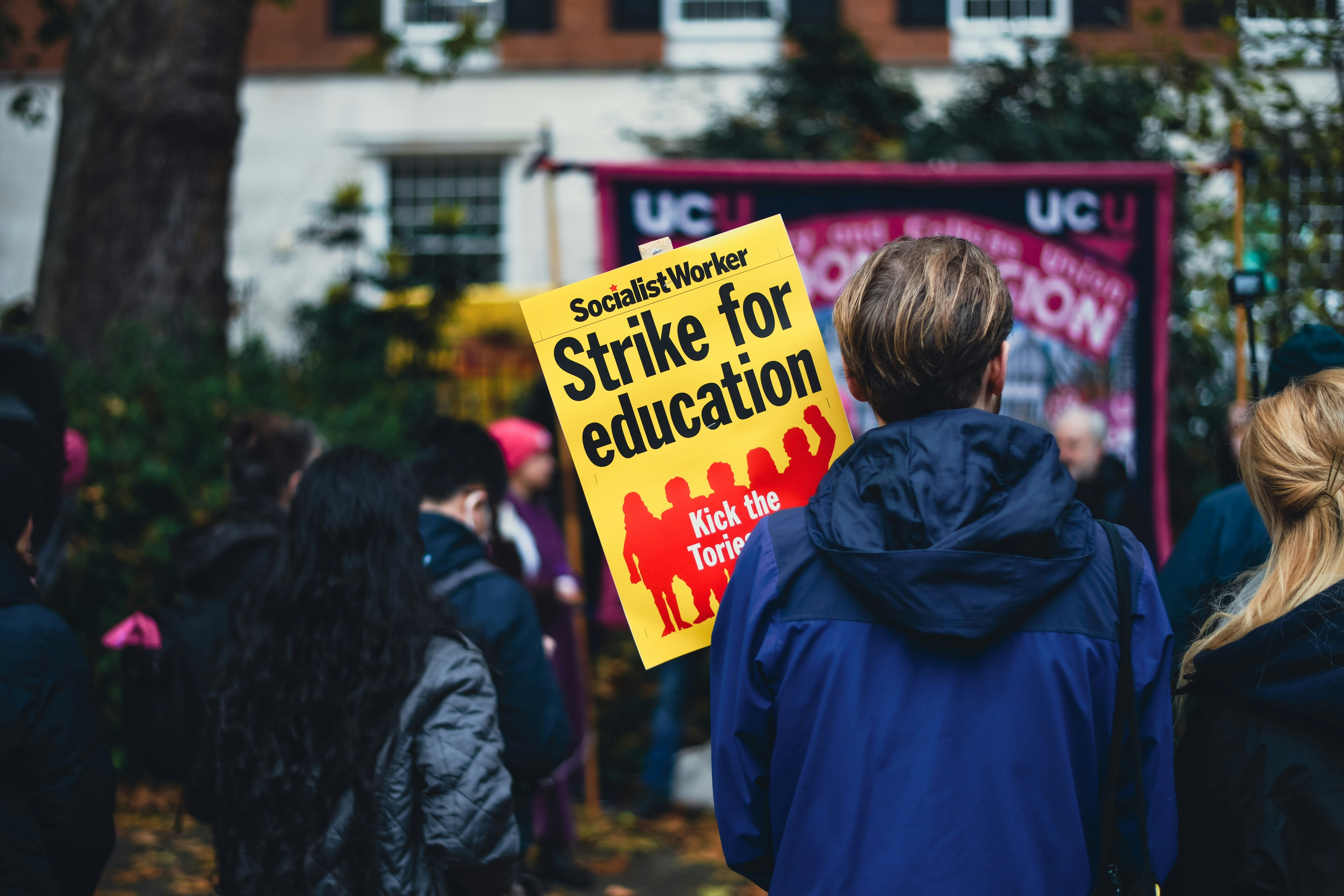 a group of people holding a strike for education sign