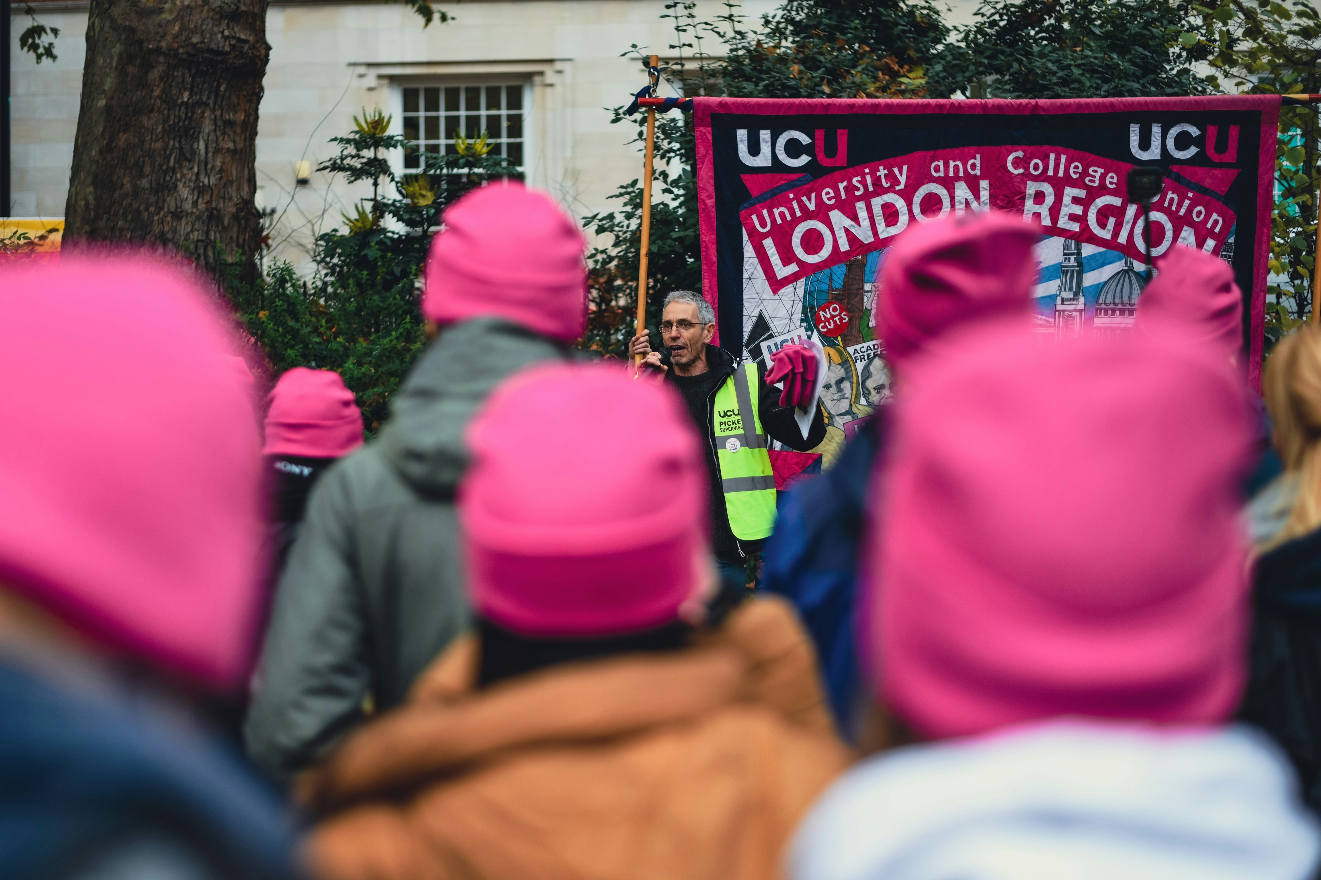 a group of people in pink hats standing in front of a sign