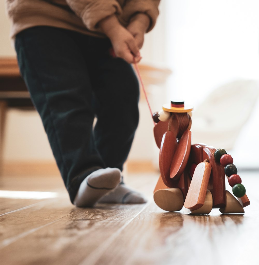 a wooden toy dog pulling a wooden toy dog on a string