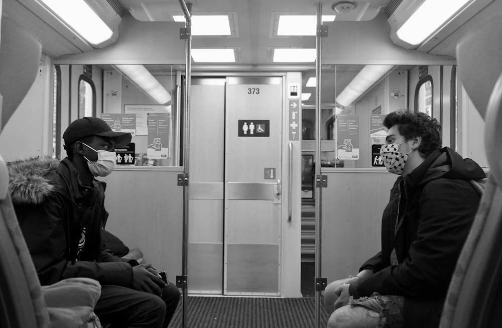 a couple of people sitting on a train next to each other