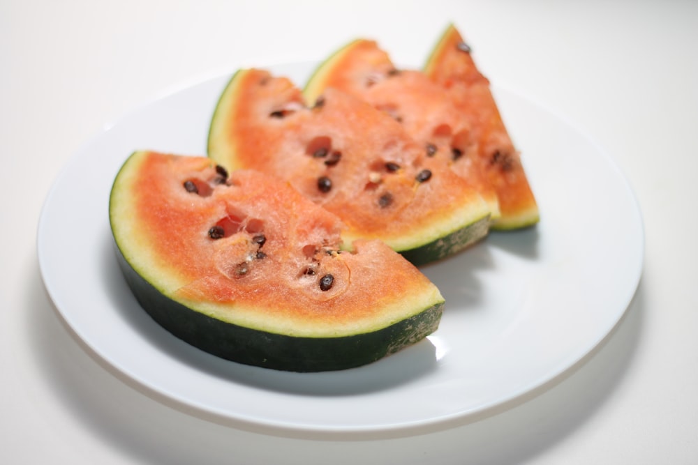 a white plate topped with slices of watermelon
