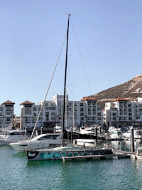 a sailboat in the water near a city