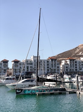 a sailboat in the water near a city