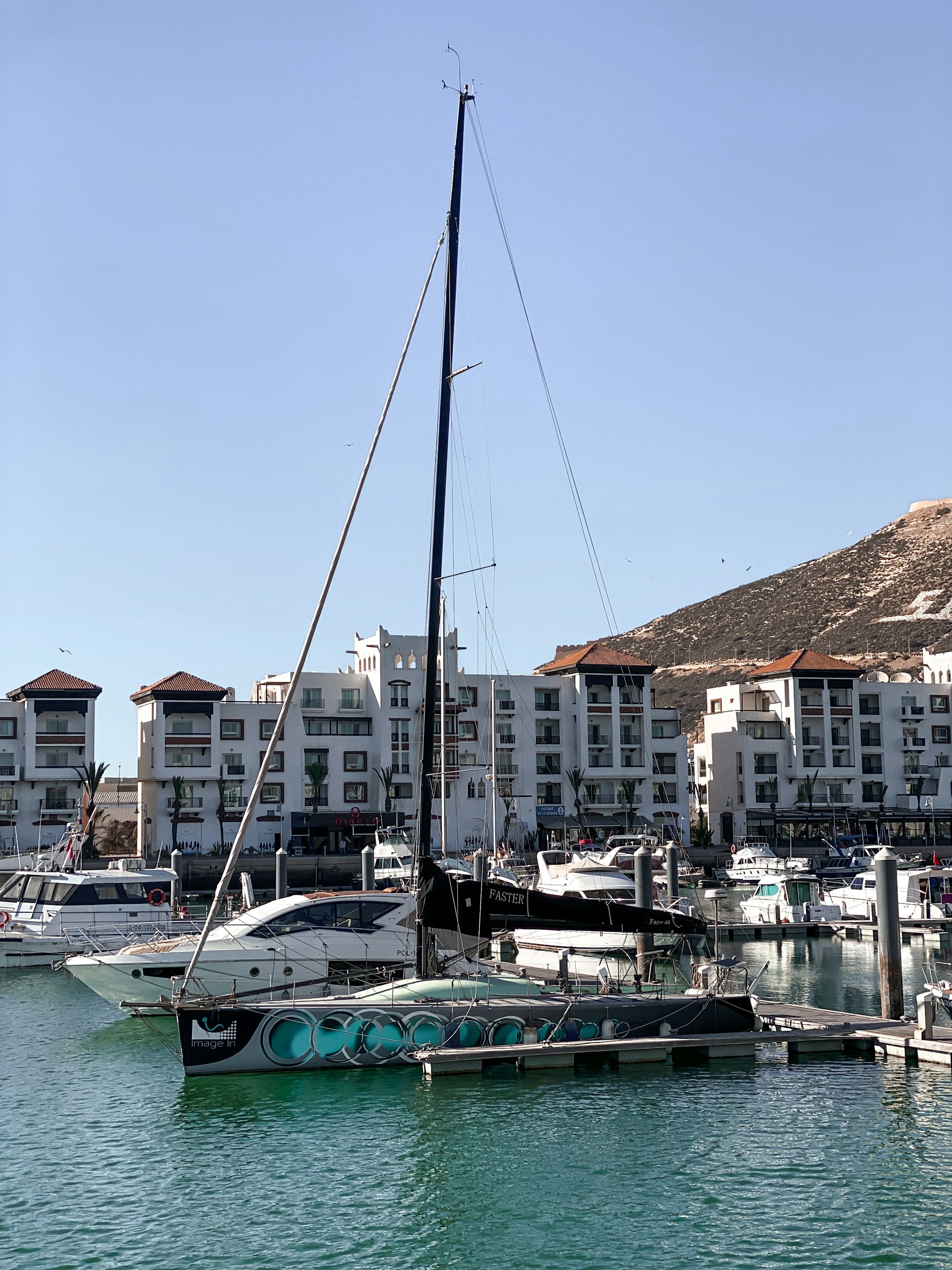 a sailboat in the water near a city