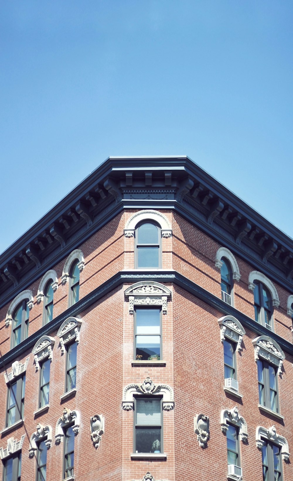 a tall brick building with a clock on the top of it