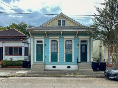 Charming townhouse with navy blue trim and neat front yard.