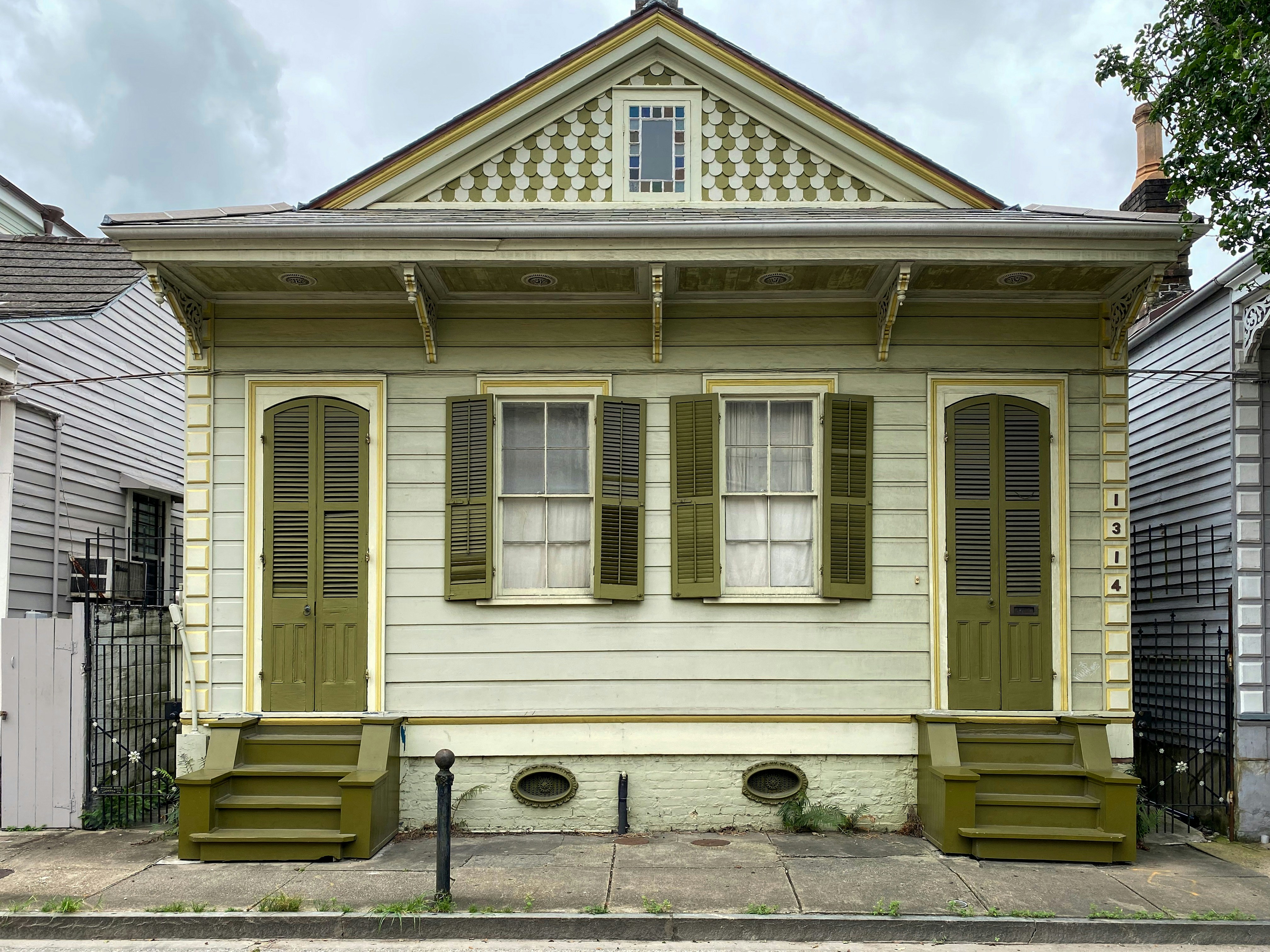 a yellow house with green shutters on the front of it