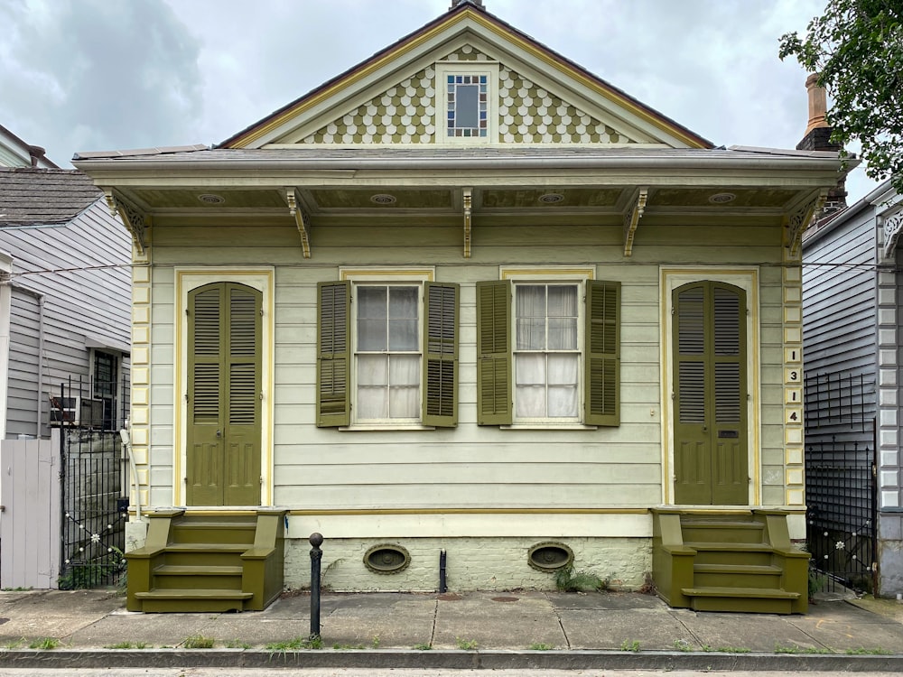 a yellow house with green shutters on the front of it