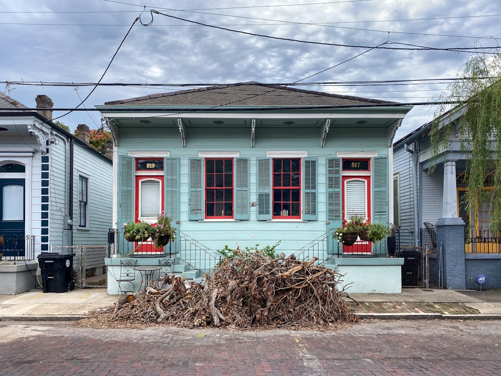 a blue house with red shutters on the windows