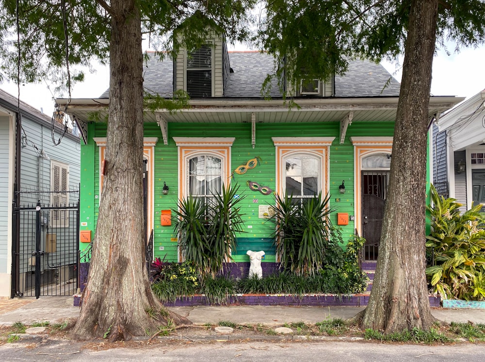 a green house with a white cat in front of it