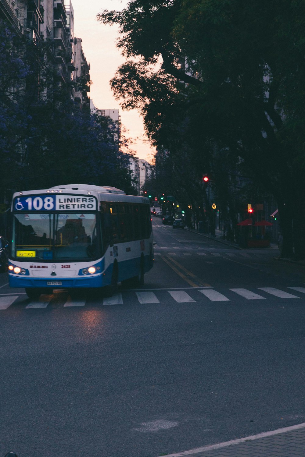 a bus driving down a street next to tall buildings