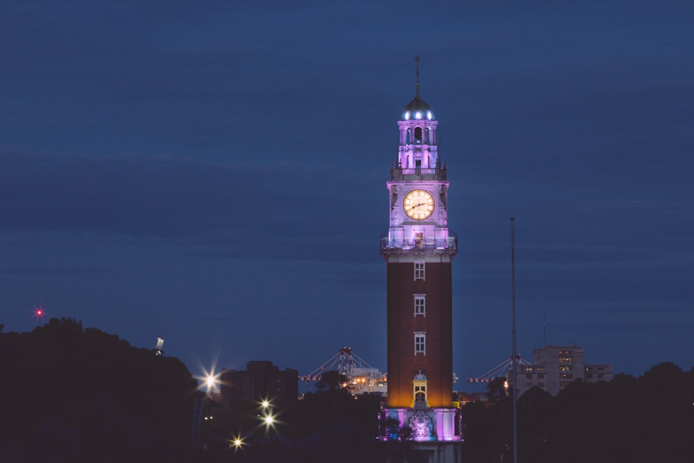 a large clock tower lit up at night