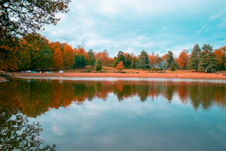 A scenic lake reflecting autumn trees with colorful leaves near a peaceful campground.