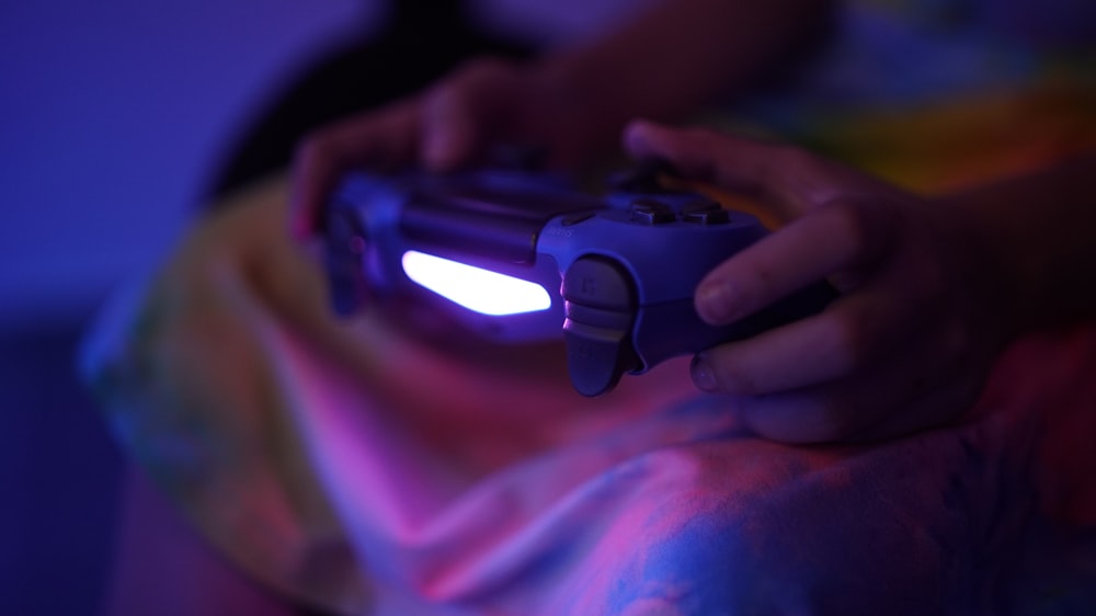 a close up of a person holding a video game controller