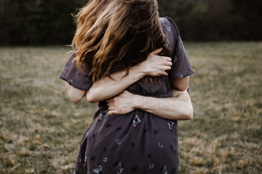 Eine Frau, die auf einem Feld steht und ihre Haare im Wind wehen