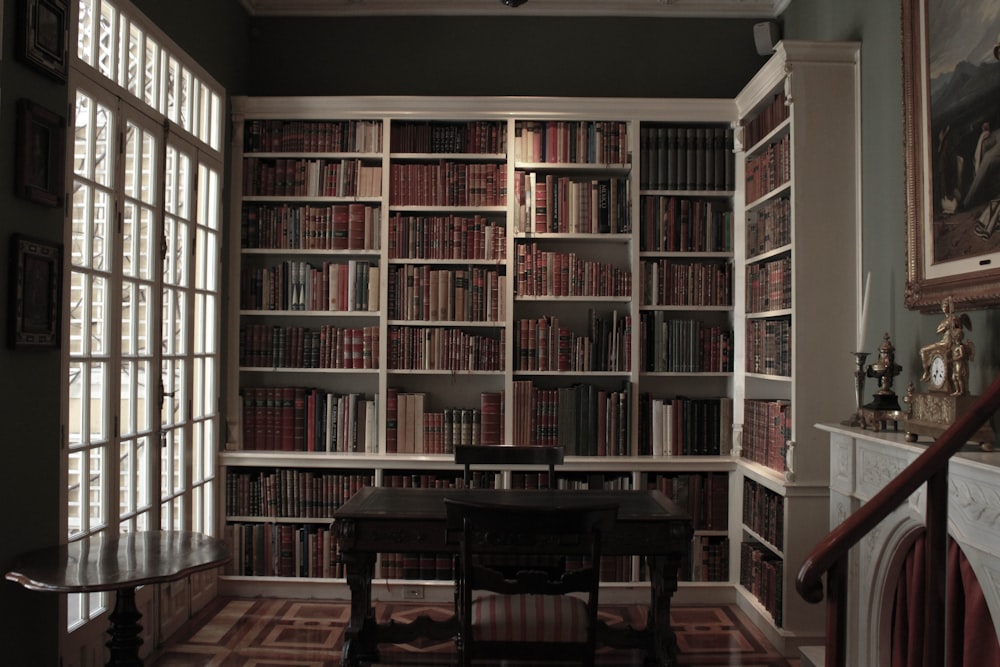 una stanza piena di molti libri e un tavolo