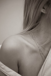 a black and white photo of a woman wearing a necklace