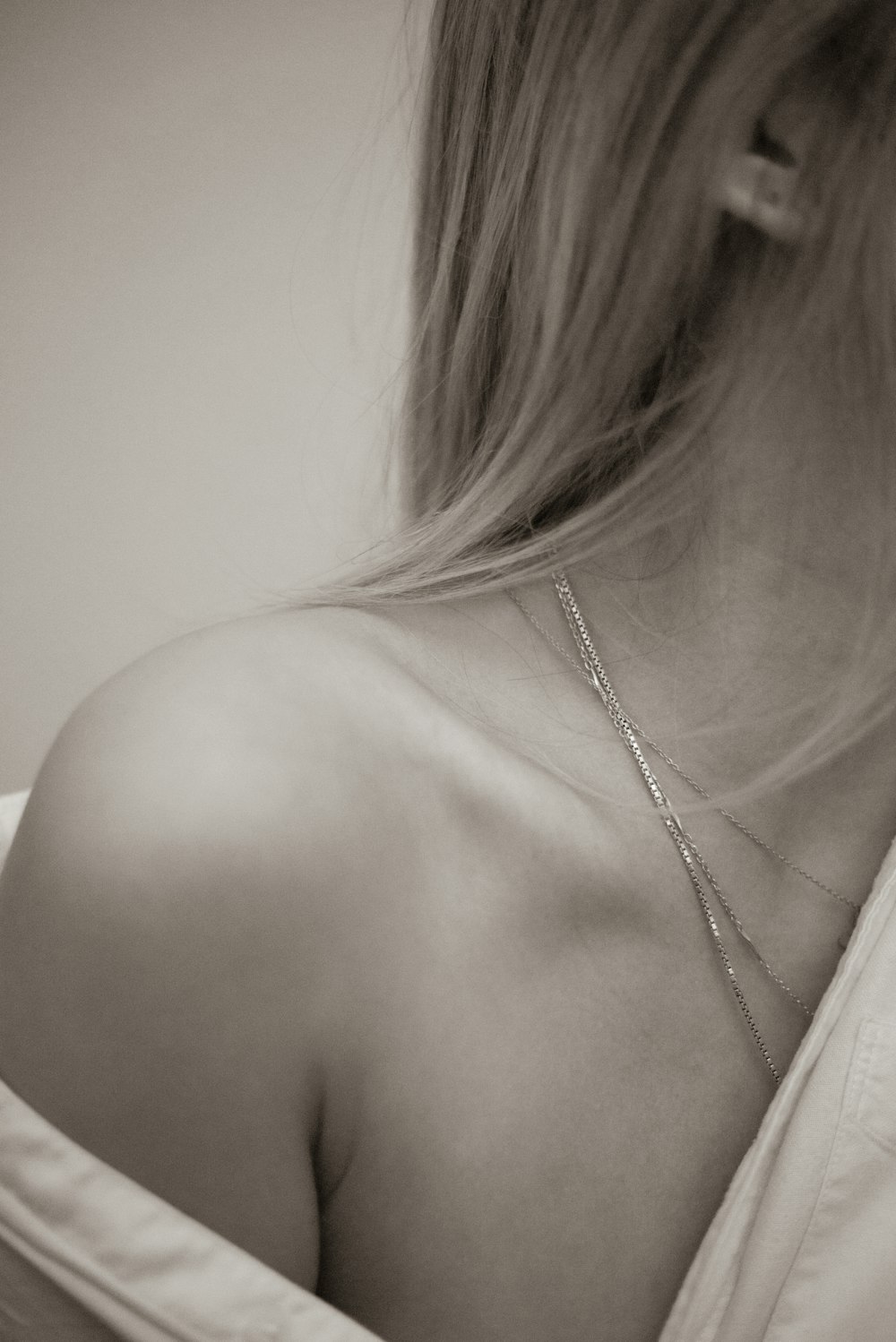 a black and white photo of a woman wearing a necklace